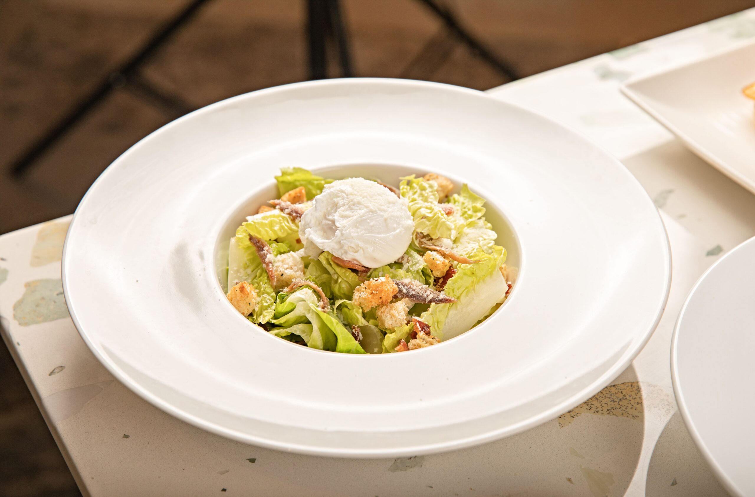 Bucătarii din întreaga lume au început să adapteze rețeta și să adauge carne, pește sau alte ingrediente pentru a transforma salata într-un fel principal. Foto: pexels.com