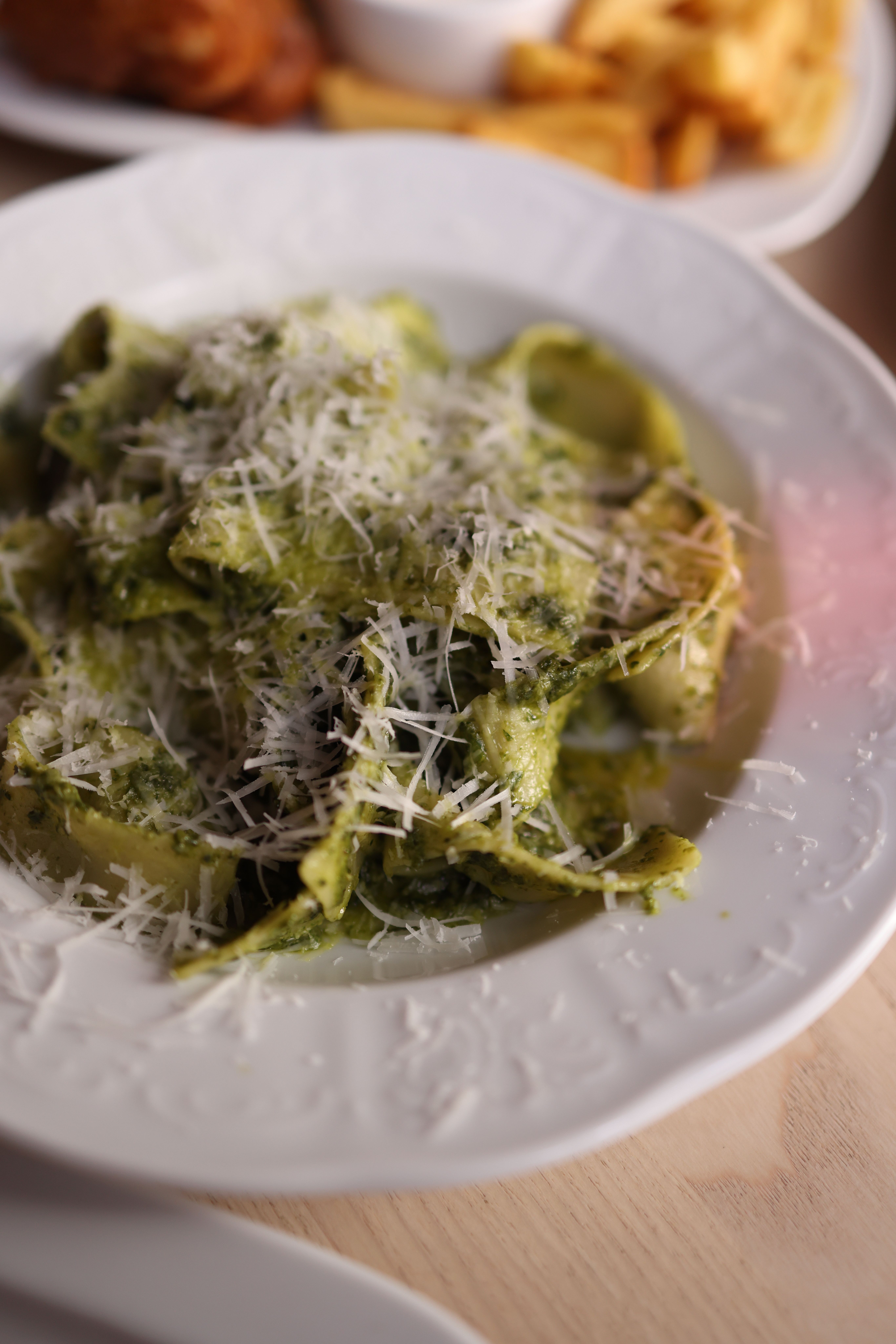 Spaghetele sunt combinate cu pesto de busuioc, piept de pui rumenit pe grill, muguri de pin și parmezan. Foto: pexels.com